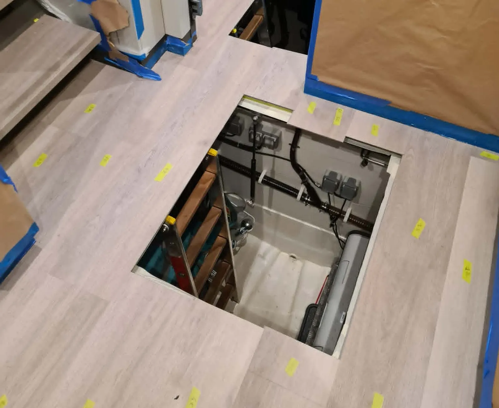 Otwarty luk serwisowy wpasowany w nową podłogę, widoczna instalacja pod pokładem